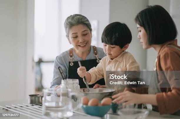 Asian Chinese Multi Generation Family Preparing Food With Flour Baking At Kitchen Counter Together Stock Photo - Download Image Now