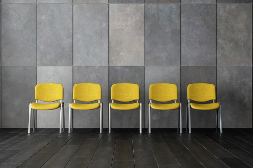 Empty Waiting Room With Yellow Chairs, Gray Color Granite Wall And Black Parquet Floor.