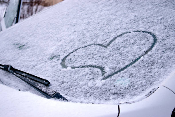 istock Finger-drawn heart on the snow-covered windshield of a car.Valentine's Day concept.Creative Valentine's Day background. Copy space for text. 1297149621