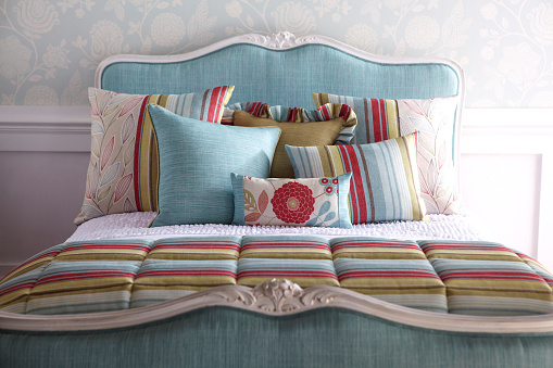 Shot of classic colorful bedroom in the minimalistic style, multicolored pillows on the bed