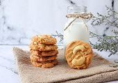 istock Cashew nut cookies with milk on the sackcloth of the white marble background 1297149775