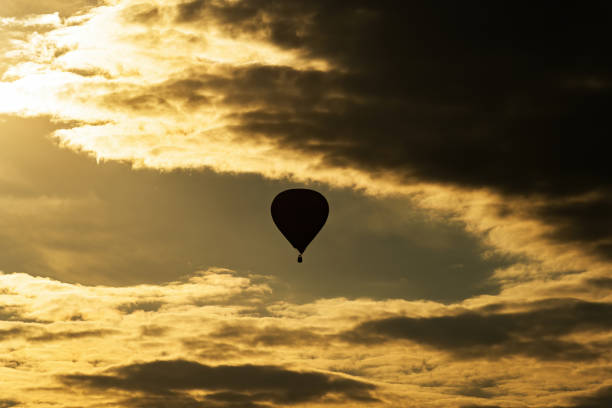 istock Hot air balloon on evening sky with clouds 1297150800