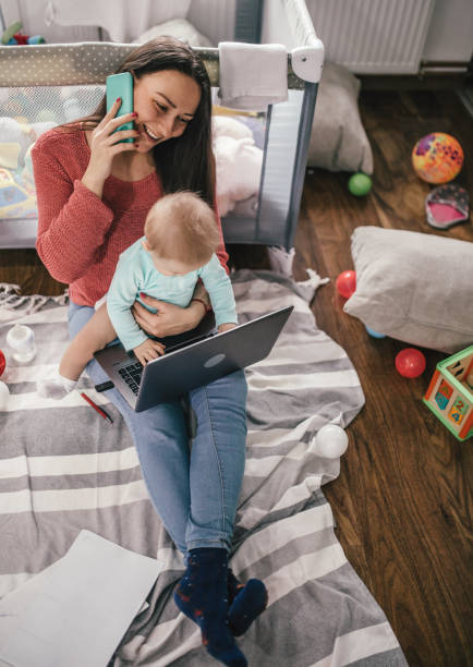 istock Young modern mother with a baby using laptop at home 1297152500