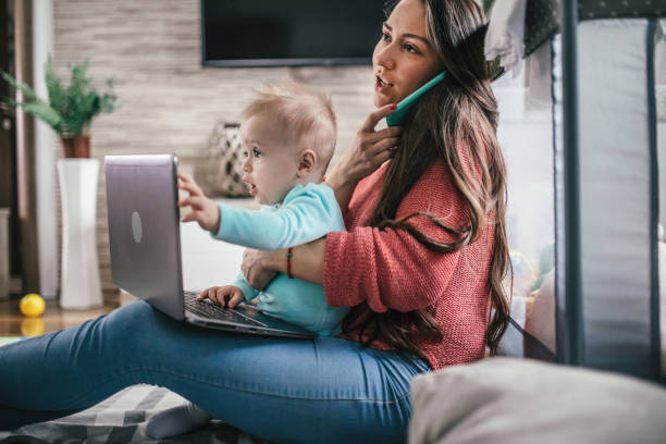 istock Young modern mother with a baby using laptop at home 1297152699