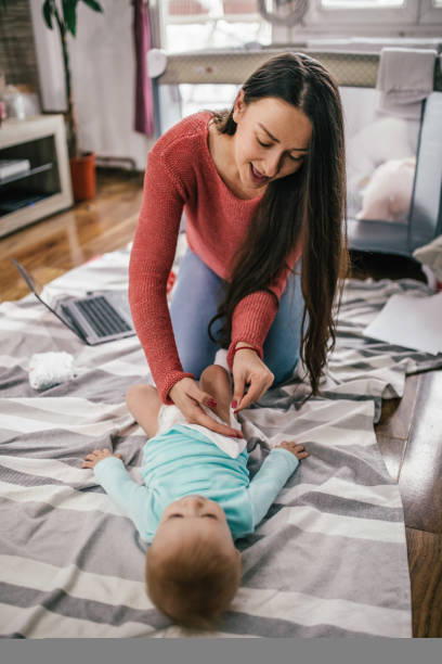 istock Young modern mother with a baby using laptop at home 1297152700