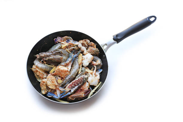 Raw fresh Prawns and Crab on frying pan isolated over white background.