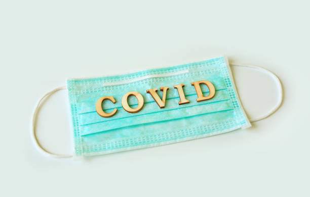 istock Medical shielding mask with word COVID isolated over white background. 1297152765