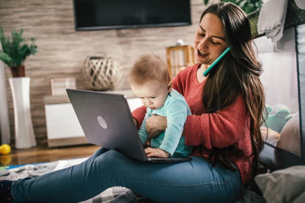istock Young modern mother with a baby using laptop at home 1297152878