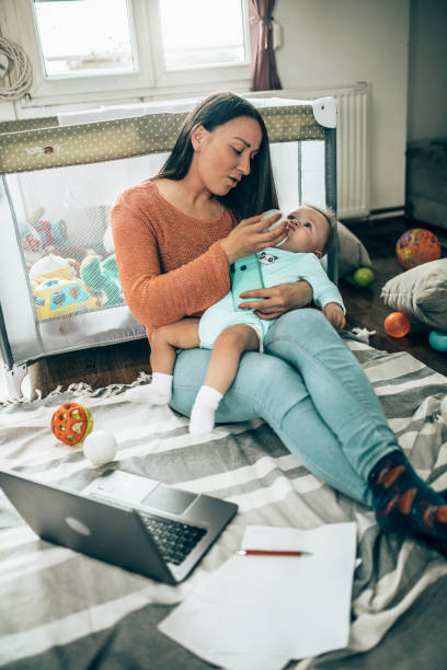 istock Young modern mother with a baby using laptop at home 1297152962