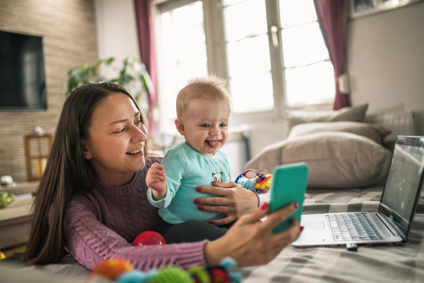 istock Young modern mother with a baby using laptop at home 1297153810