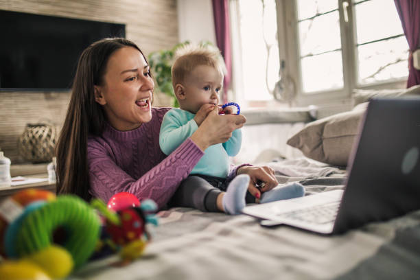 istock Young modern mother with a baby using laptop at home 1297153876