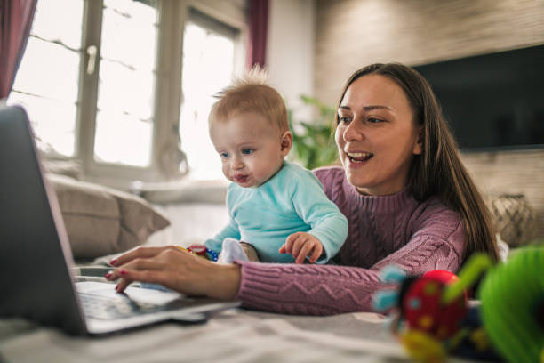 istock Young modern mother with a baby using laptop at home 1297153906
