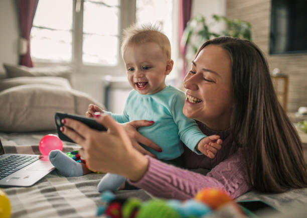 istock Young modern mother with a baby using laptop at home 1297153907