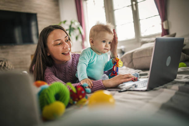 istock Young modern mother with a baby using laptop at home 1297153939