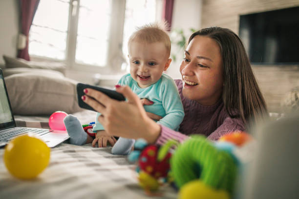 istock Young modern mother with a baby using laptop at home 1297153952