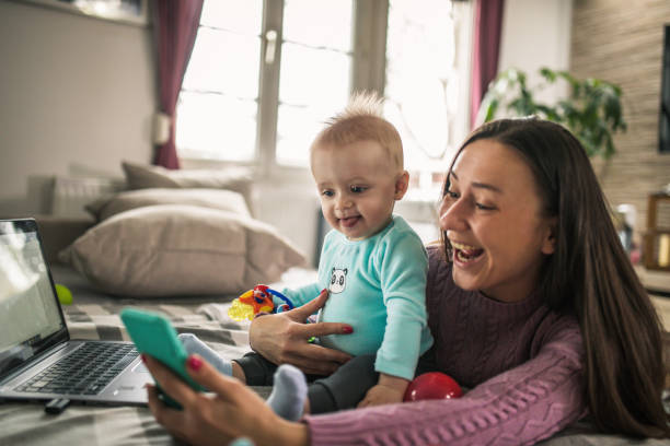 istock Young modern mother with a baby using laptop at home 1297153969