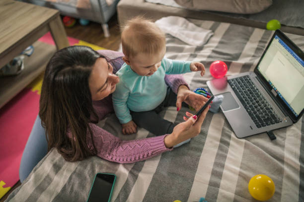 istock Young modern mother with a baby using laptop at home 1297154004