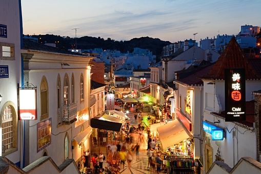 Elevated view of the R 5 de Outubro shopping street in the evening with tourists enjoying the setting, Albufeira, Portugal, Europe.
