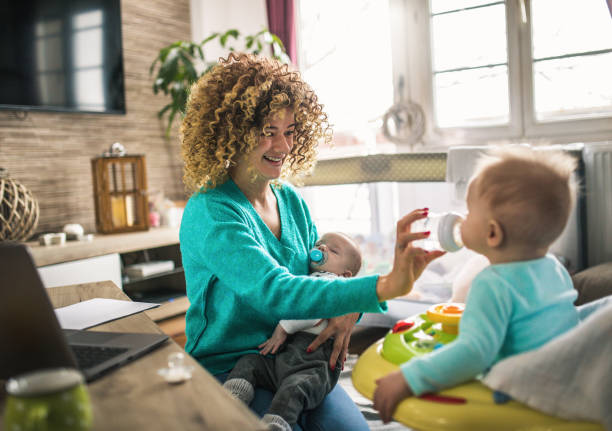 istock Young modern mother with a baby using laptop at home 1297154854