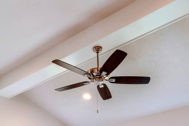 istock Decorative wood beam with standard ceiling fan and lights inside a house 1297156031