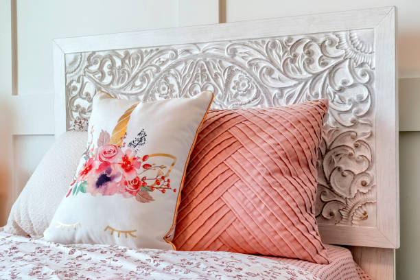 istock Fluffy pillows against decorative headboard of single bed against panelled wall 1297156083