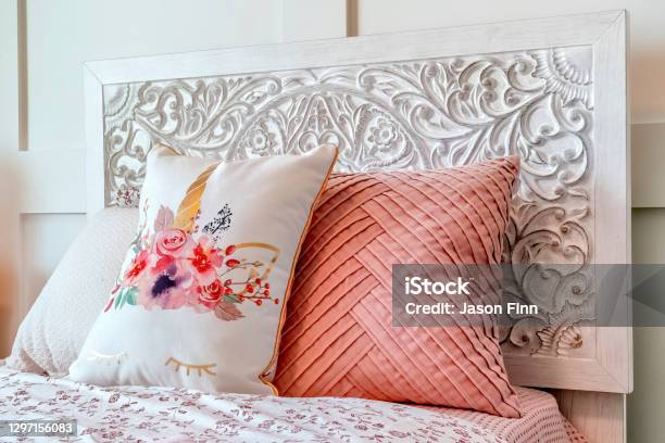 Fluffy Pillows Against Decorative Headboard Of Single Bed Against Panelled Wall Stock Photo - Download Image Now