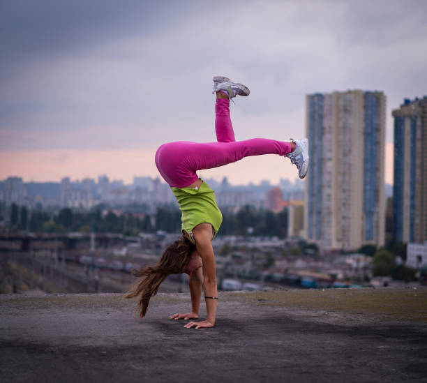 гибкая девушка держать баланс на руках на фоне городского пейзажа . концепция творчества, равновесия и индивидуальности - yoga city handstand control стоковые фото и изображения