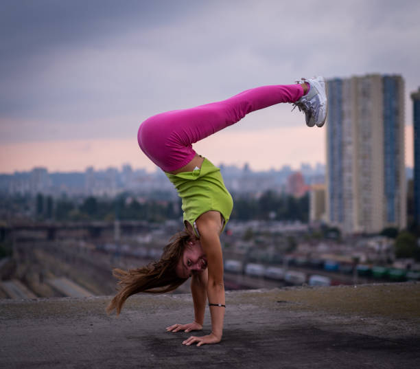 гибкая девушка держать баланс на руках на фоне городского пейзажа . концепция творчества, равновесия и индивидуальности - yoga city handstand control стоковые фото и изображения