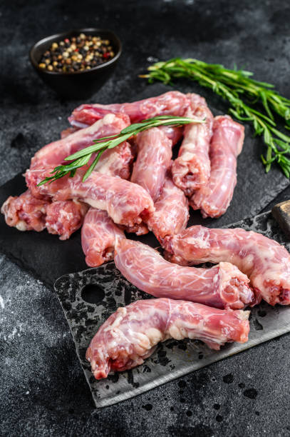 istock Raw Turkey neck meat on a cutting board. Black background. Top view 1297158563