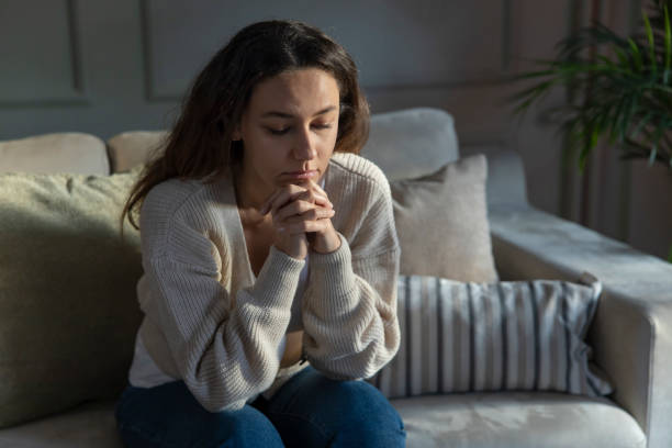 istock Depressed young woman on sofa at home 1297159380