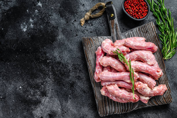 istock Raw chicken neck meat on a cutting board. Black background. Top view. Copy space 1297159436