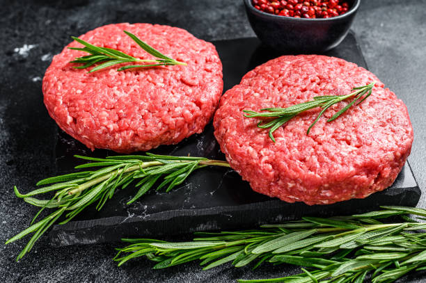 galette de viande hachée pour hamburger.  fond noir. vue supérieure - ground beef photos photos et images de collection