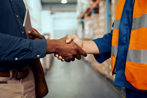 istock Midsection view of two male workers shaking hands at factory 1297160705