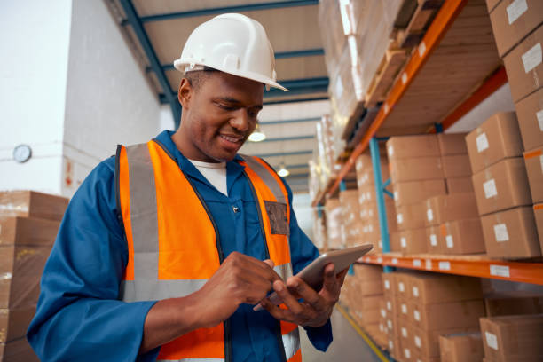 istock Happy african industrial staff using digital tablet in large warehouse 1297160830