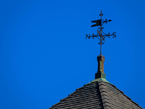 A weather vane or wind vane is an instrument used for showing the direction of the wind. It is typically used as an architectural ornament to the highest point of a building. Place for text.