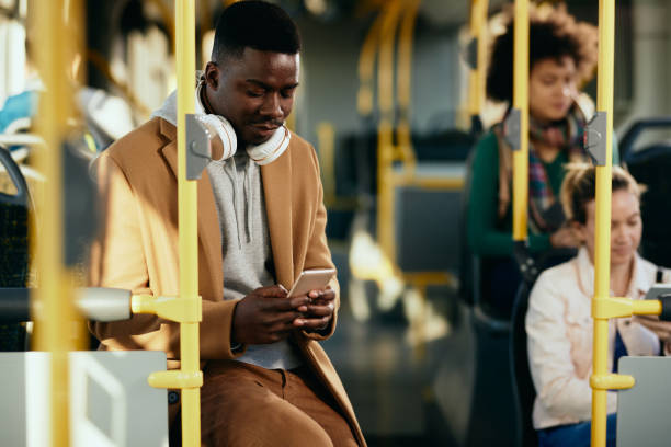 istock African American man text messaging on cell phone while commuting by public transport. 1297165872