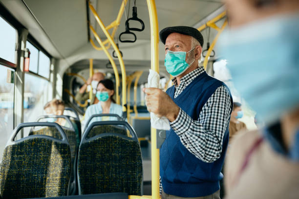 istock Senior man with protective face mask commuting by public transport. 1297165983
