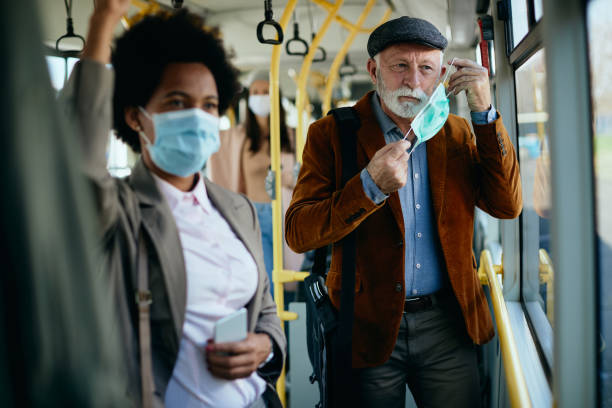 istock Mature man putting on protective face mask in a public transport. 1297166015