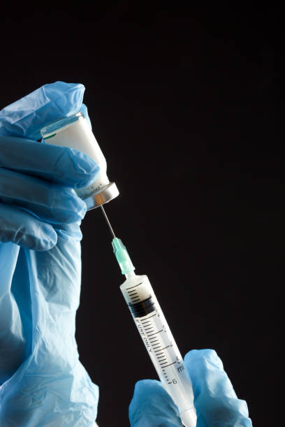 istock Scientist or medical worker holds Corona virus vaccine bottle.Vaccination, immunization, treatment to cure Covid 19 infection. Healthcare And Medical concept. 1297166242
