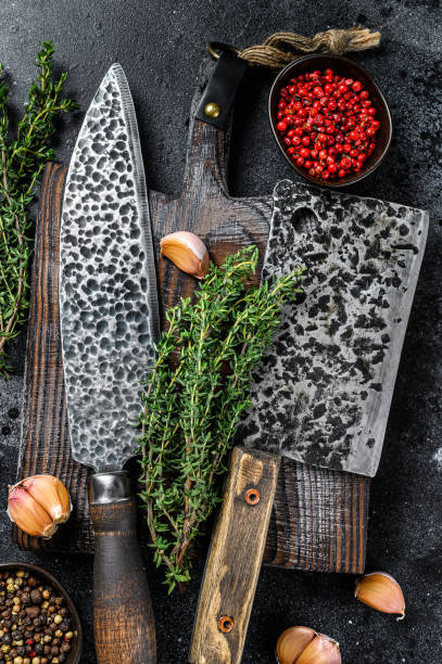 istock Chopping board and meat cleaver with knife. Black background. Top view 1297167405