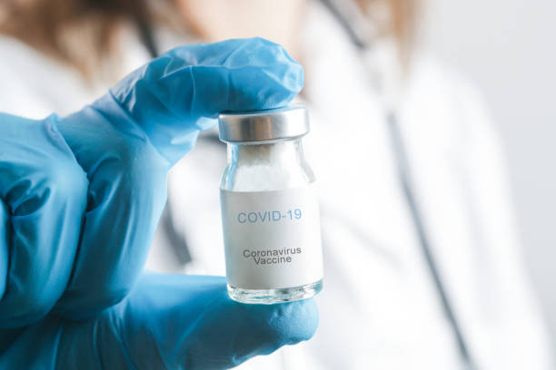 istock Scientist or medical worker holds Corona virus vaccine bottle.Vaccination, immunization, treatment to cure Covid 19 infection. Healthcare And Medical concept. 1297168890