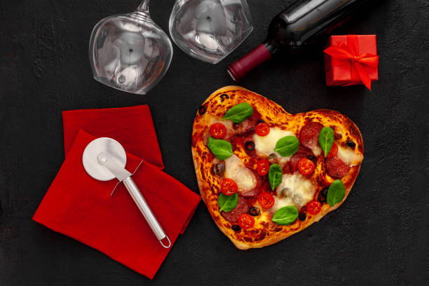 istock Valentine's day table setting. Heart pizza with wine, glasses and 1297169568
