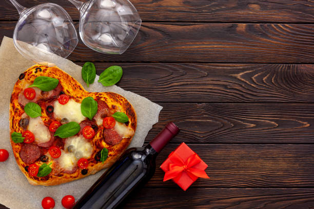 istock Heart pizza with a bottle wine, glasses and gift box 1297169674