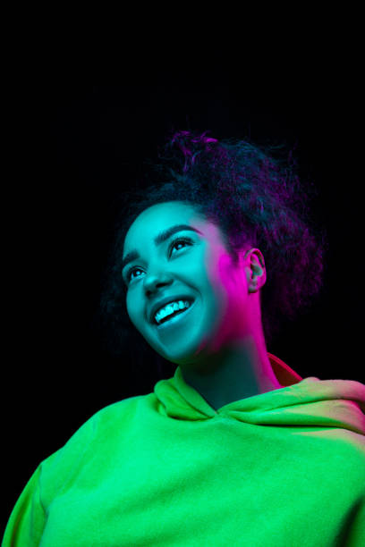 istock African-american woman's portrait isolated on dark studio background in multicolored neon light 1297171630