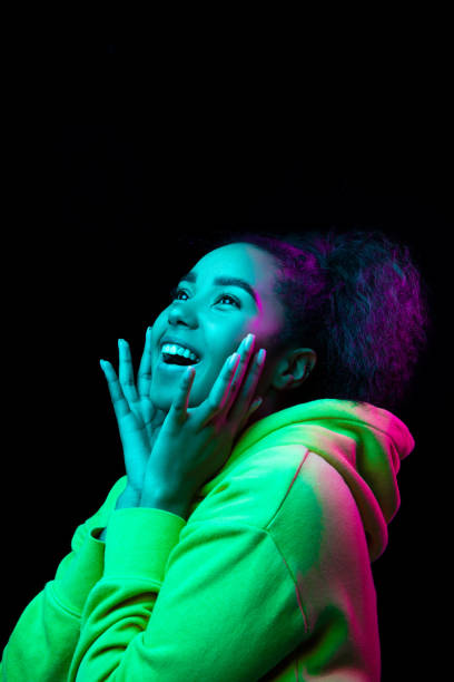 istock African-american woman's portrait isolated on dark studio background in multicolored neon light 1297171636