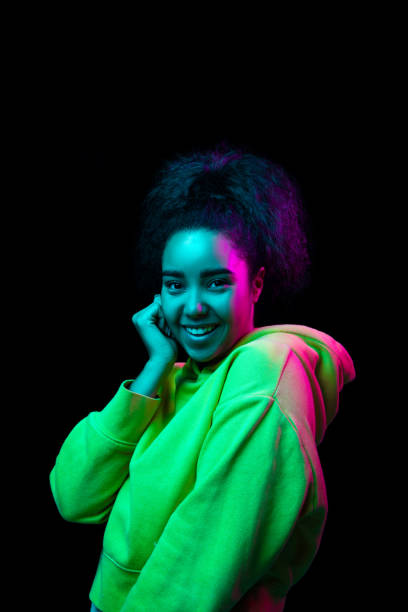 istock African-american woman's portrait isolated on dark studio background in multicolored neon light 1297171638