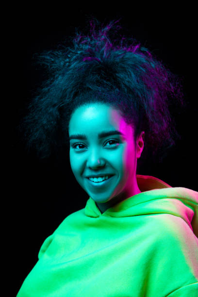 istock African-american woman's portrait isolated on dark studio background in multicolored neon light 1297171639
