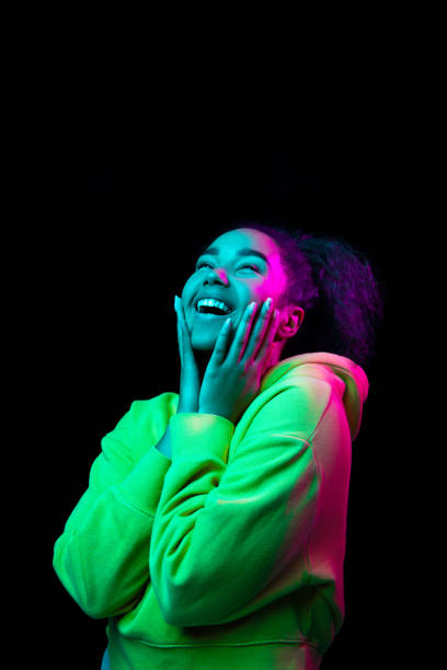African-american woman's portrait isolated on dark studio background in multicolored neon light