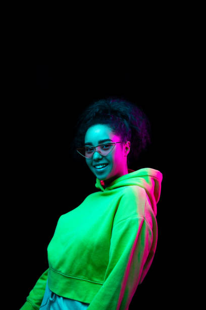 istock African-american woman's portrait isolated on dark studio background in multicolored neon light 1297171642