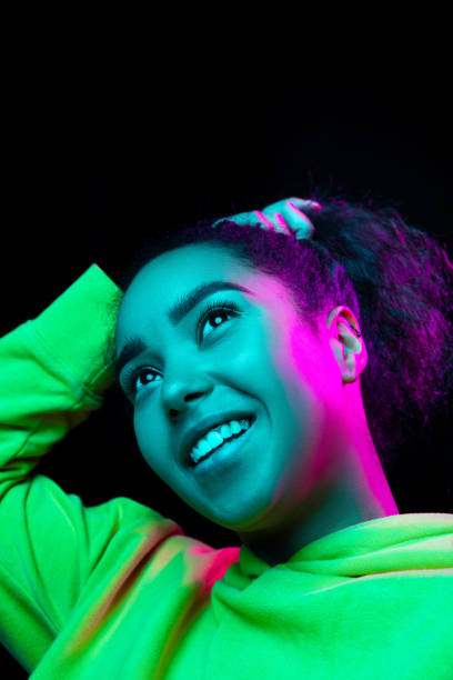 istock African-american woman's portrait isolated on dark studio background in multicolored neon light 1297171643